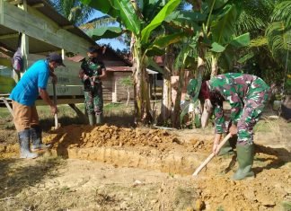 Anggota Satgas TMMD Goro Bersama Warga Bersihkan Parit Jalan