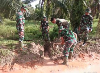 Diguyur Hujan Deras, Anggota Satgas TMMD Goro Buang Genangan Air
